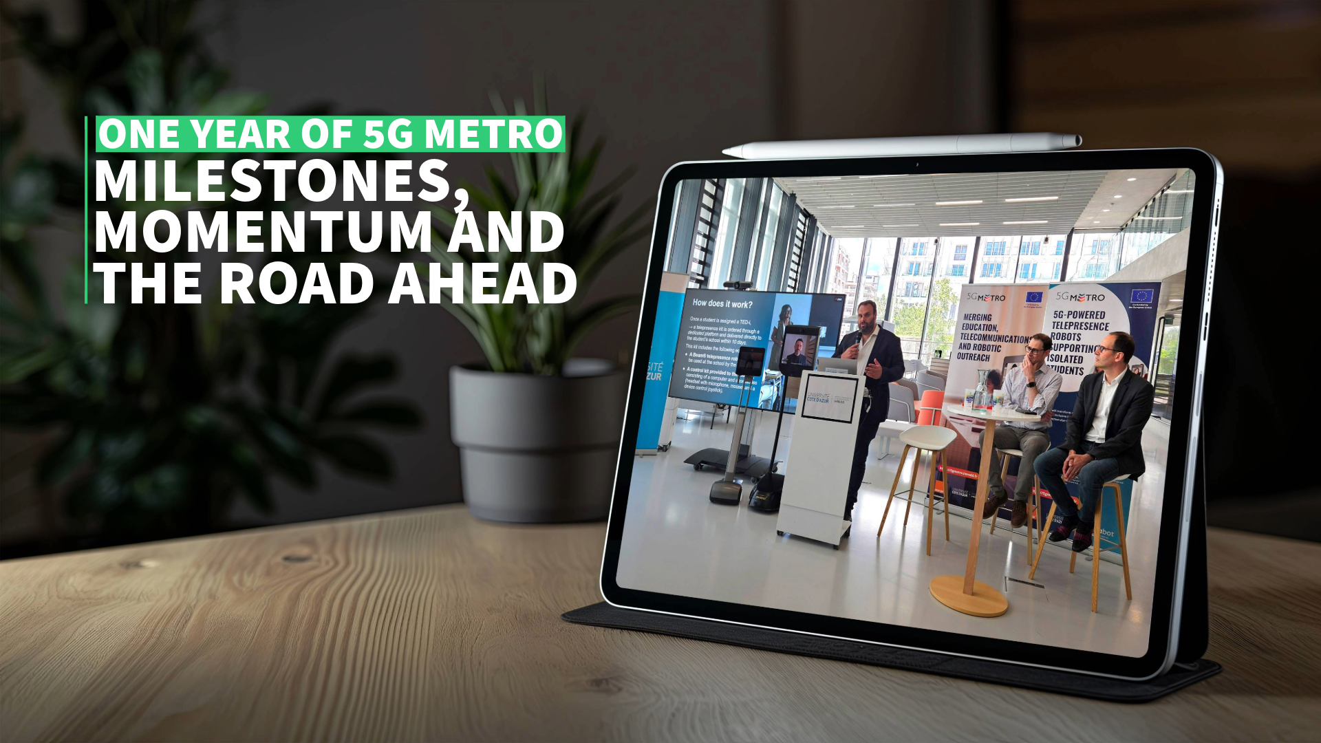 5G Metro first anniversary illustration image : a photograph of the launch event seen on the screen of a tablet propped on a table.